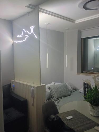 a room with a couch and a neon sign on the wall at Studio Alto Padrão Centro do Rio in Rio de Janeiro