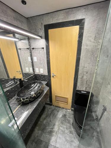 a bathroom with a sink and a glass door at Studio Alto Padrão Centro do Rio in Rio de Janeiro