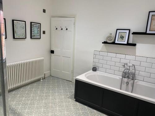 ein Bad mit einer Badewanne in einem Zimmer in der Unterkunft Town centre Victorian period 3 bedroom home in Bishops Castle