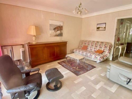 un salon avec un canapé et une chaise dans l'établissement Appartement F2 avec terrasse, parking, ascenseur et WIFI - Animaux acceptés - Amélie-les-Bains - FR-1-703-86, à Amélie-les-Bains-Palalda