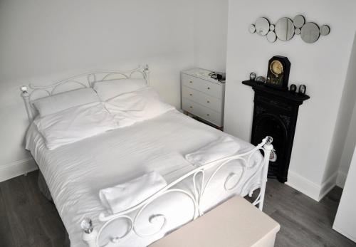 a bedroom with a white bed and a black dresser at The Great Escape by Tŷ SA in Newport