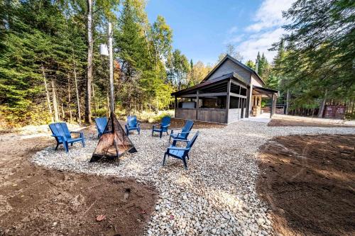 a group of chairs sitting in front of a cabin at Spa and Nature - Chalet des Pins Rouge in Saint-Paul-de-Montminy