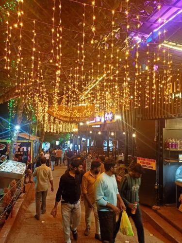 a group of people walking around a market with lights at ARONIC beach hotel in Varkala