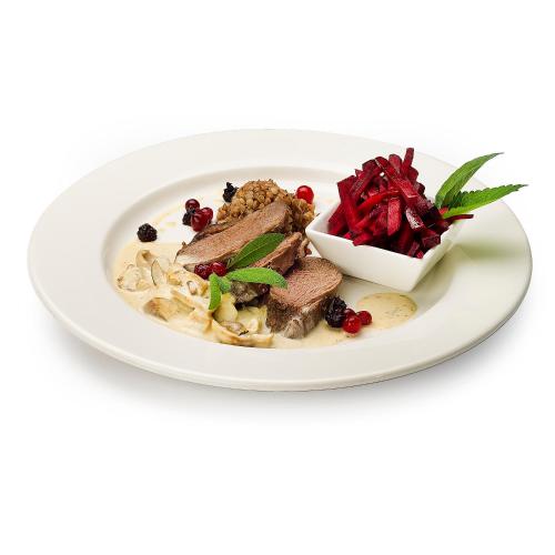 a plate of food with meat and a bowl of red peppers at Zamek w Krasiczynie in Krasiczyn