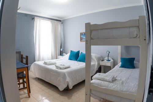 a bedroom with two beds and a bunk bed at Rumel Quimey Quipan in Puerto Madryn