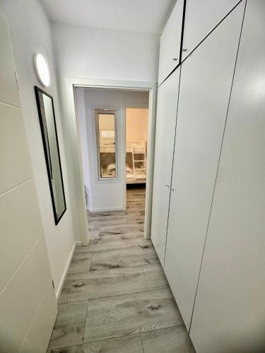a hallway with white walls and wood floors and a room at Ferienwohnung Alfred mit Sauna Marina Wendtorf, bei Laboe in Wendtorf