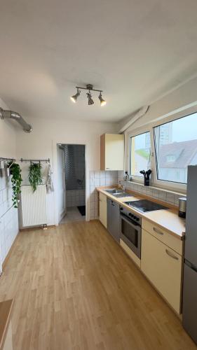 a kitchen with wooden floors and a large window at schöne 3 Zimmerwohnung Altbau, hochschulnah, free parking in Aalen