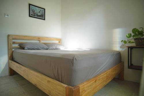 a bed in a room with a wooden frame at KOTTA Hostel in Timuran