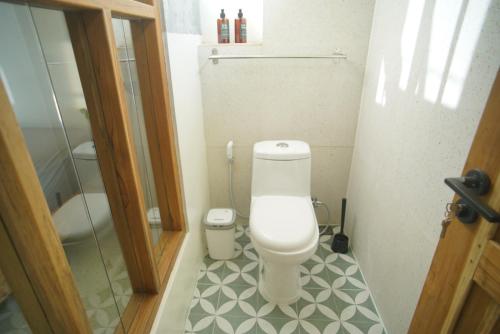 a small bathroom with a toilet and a shower at KOTTA Hostel in Timuran