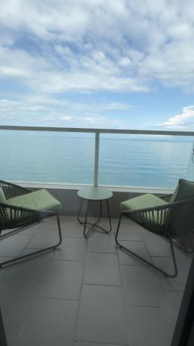 two chairs and a table on a balcony with the ocean at Go-Bamboo Beach Residence in Tsikhisdziri