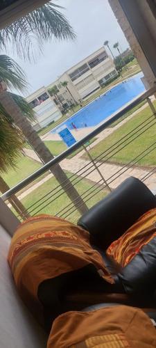 a view of a swimming pool from a window with a couch at Ola Blanca in Dar Hamida