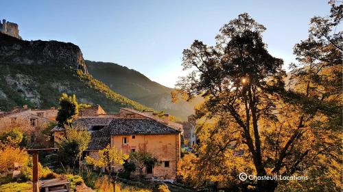 a village in the mountains with the sun shining on it at Verdon BnB calm comfort and epic nature views in Castellane