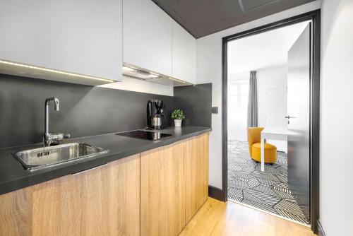 a kitchen with a sink and a mirror at Appart'City Collection Nîmes Arènes in Nîmes