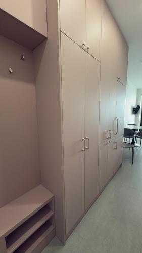a room with white cabinets and a table and a chair at Go-Bamboo Beach Residence in Tsikhisdziri