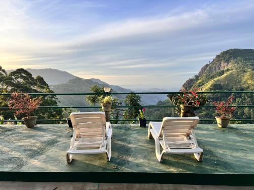 two chairs on a balcony with a view of mountains at Ambiente Guest House in Ella