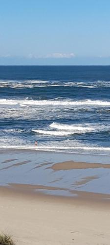 a person walking on the beach near the ocean at Chale dos Sobreiros in Bicas