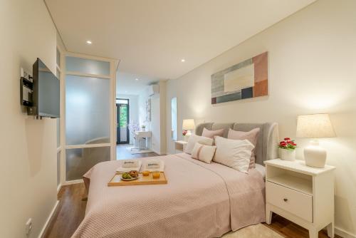 a bedroom with a bed with a tray of food on it at Host Wise - Marquesa Palace in Porto