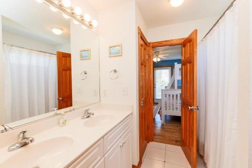 a bathroom with two sinks and a mirror at Soundside, Private Pool, Hot Tub, Rec Room-VOH50, Castle in the Sand in Corolla