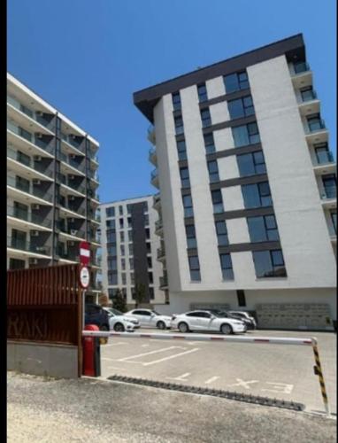 a parking lot with cars parked in front of a building at Meraki Resort & Spa Isabellae Home in Mamaia Nord