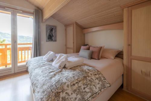 a bedroom with a large bed with towels on it at Chalet Taninges in Taninges