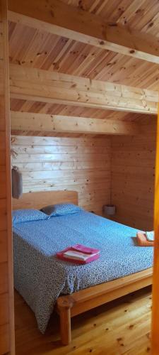 a bedroom with a bed in a wooden cabin at Chale dos Sobreiros in Bicas