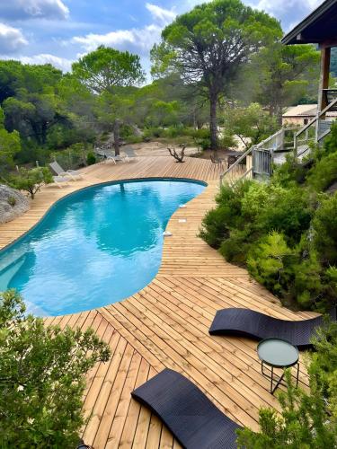 a swimming pool on a wooden deck next to a house at Villa dans Site Exceptionnel in Mourèze