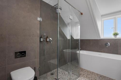 a bathroom with a shower and a toilet and a tub at Berg Apartments in Reykjavík