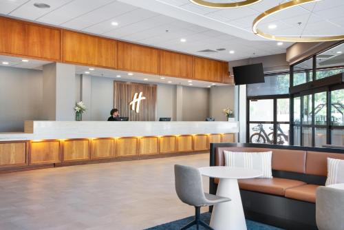 a lobby with a bar and a person sitting at a counter at Holiday Inn Portland-By the Bay by IHG in Portland