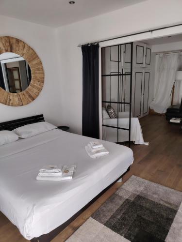 une chambre avec un lit blanc et un miroir dans l'établissement Movida, à Nice