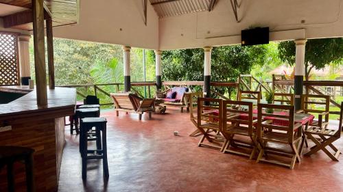 a porch with chairs and a bar with a view of the forest at Skill forest lodge in Arusha