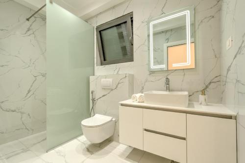 a white bathroom with a toilet and a sink at Villa Boka in Tivat