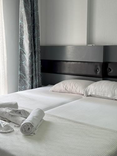 a bed with white sheets and a towel on it at Ece Han Butik Otel in Atakum