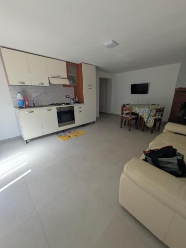 a living room with a couch and a kitchen at Appartamento a due passi dal mare in Martinsicuro