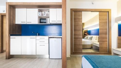 a kitchen with white cabinets and a bed in a room at Globales Verdemar in Santa Ponsa