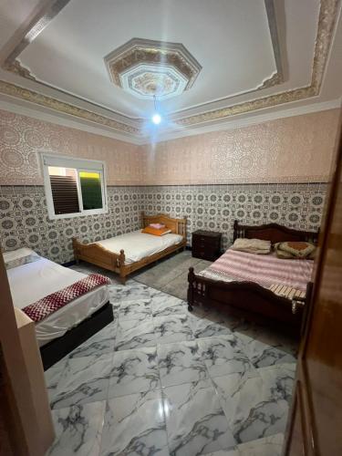 una habitación con dos camas y techo en Ezzaimi apartment, en Tánger