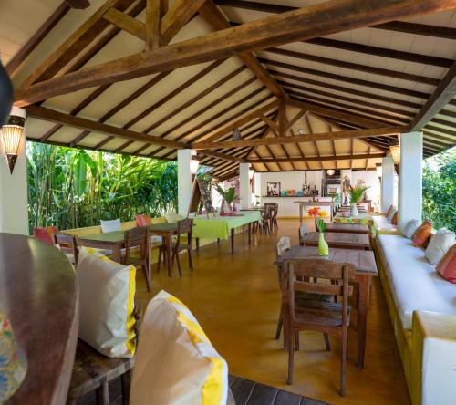 a dining room with tables and chairs and wooden ceilings at Pousada Jardim Das Margaridas in Trancoso