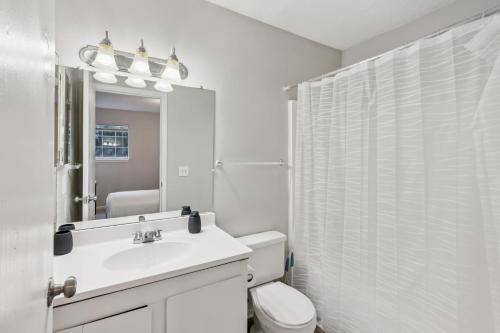 Un baño con inodoro, lavabo y espejo. en Kenridge Apartments 2605 I Comfy 2 Bed 2 Bath, en Decatur
