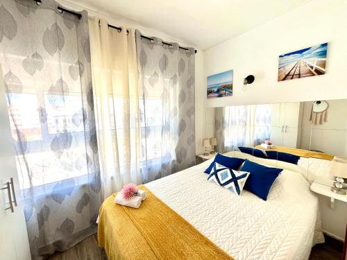 Un dormitorio con una cama con almohadas azules y una ventana. en Casa da Praia na Torre Castelo, en Armação de Pêra