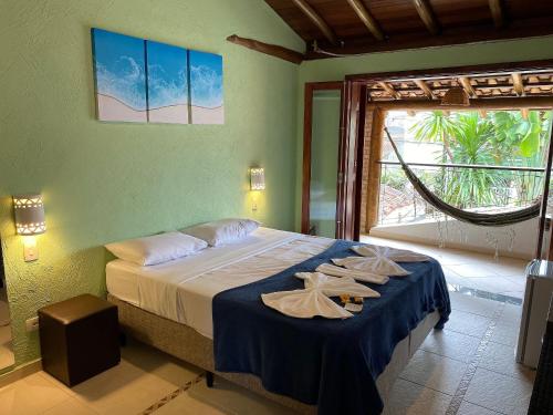 a bedroom with a bed with towels on it at Lalabella Itaguá in Ubatuba
