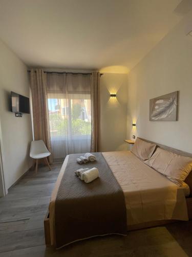 a bedroom with a large bed with towels on it at B&B Magiulsà in Siniscola