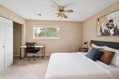 a bedroom with a bed and a desk with a ceiling fan at Kenridge Apartments 635 I Comfy 2 Bed 2 Bath in Decatur