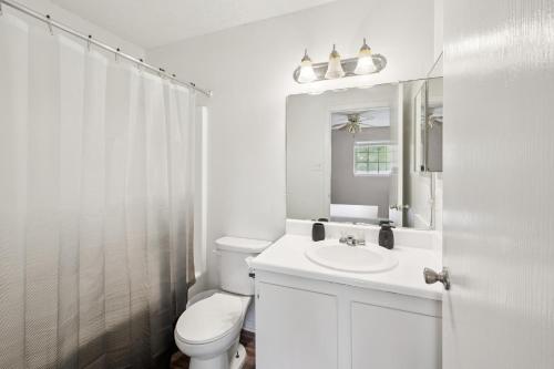 a white bathroom with a toilet and a sink at Kenridge Apartments 635 I Comfy 2 Bed 2 Bath in Decatur