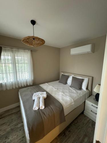 a bedroom with a bed with two towels on it at Valinor Urla in Urla