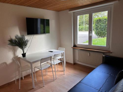 PieterlenにあるPEARL10 Apartment next to the Daisiesのテーブルと椅子とテレビのあるリビングルーム
