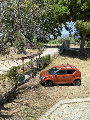 an orange car parked on the side of a road at Βίλα Θαλεια in Káto Lekhónia