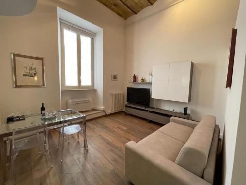 Una sala de estar con un sofá y una mesa de cristal. en Foro Romano Apartments D, en Roma