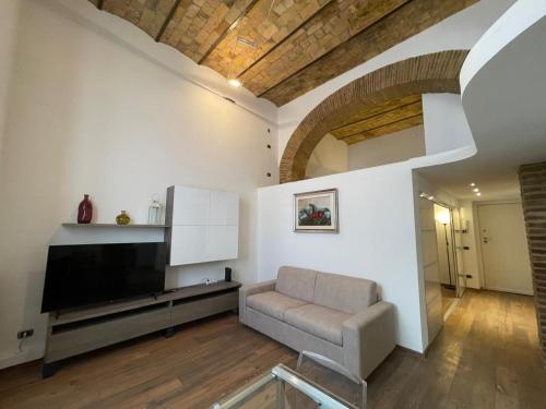 Una sala de estar con un sofá y un televisor de pantalla plana. en Foro Romano Apartments D, en Roma