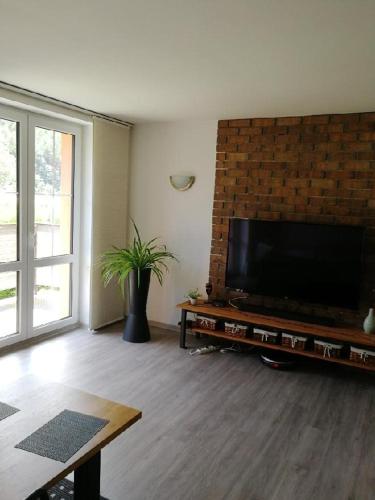 a living room with a large television on a brick wall at Apartmán Červený Vrch in Děčín