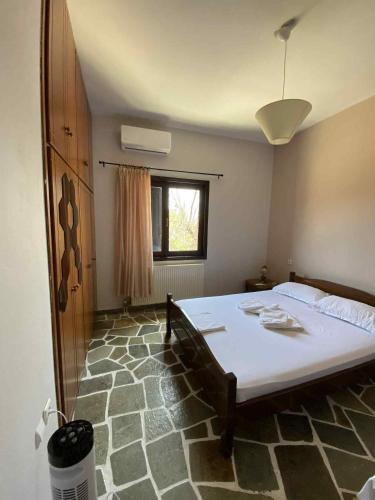 a bedroom with a large bed and a window at Βίλα Θαλεια in Káto Lekhónia