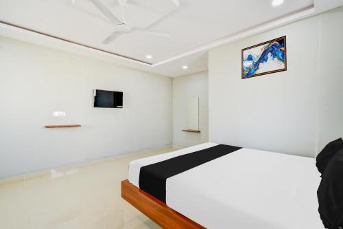 a bedroom with a bed and a tv on the wall at Hotel O SSR Grand in Surūrnagar